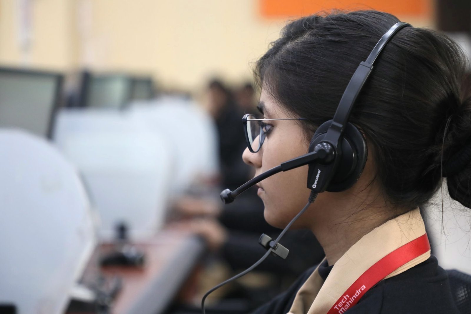 Side view of an operator at a keyboard with a headset in a working office.