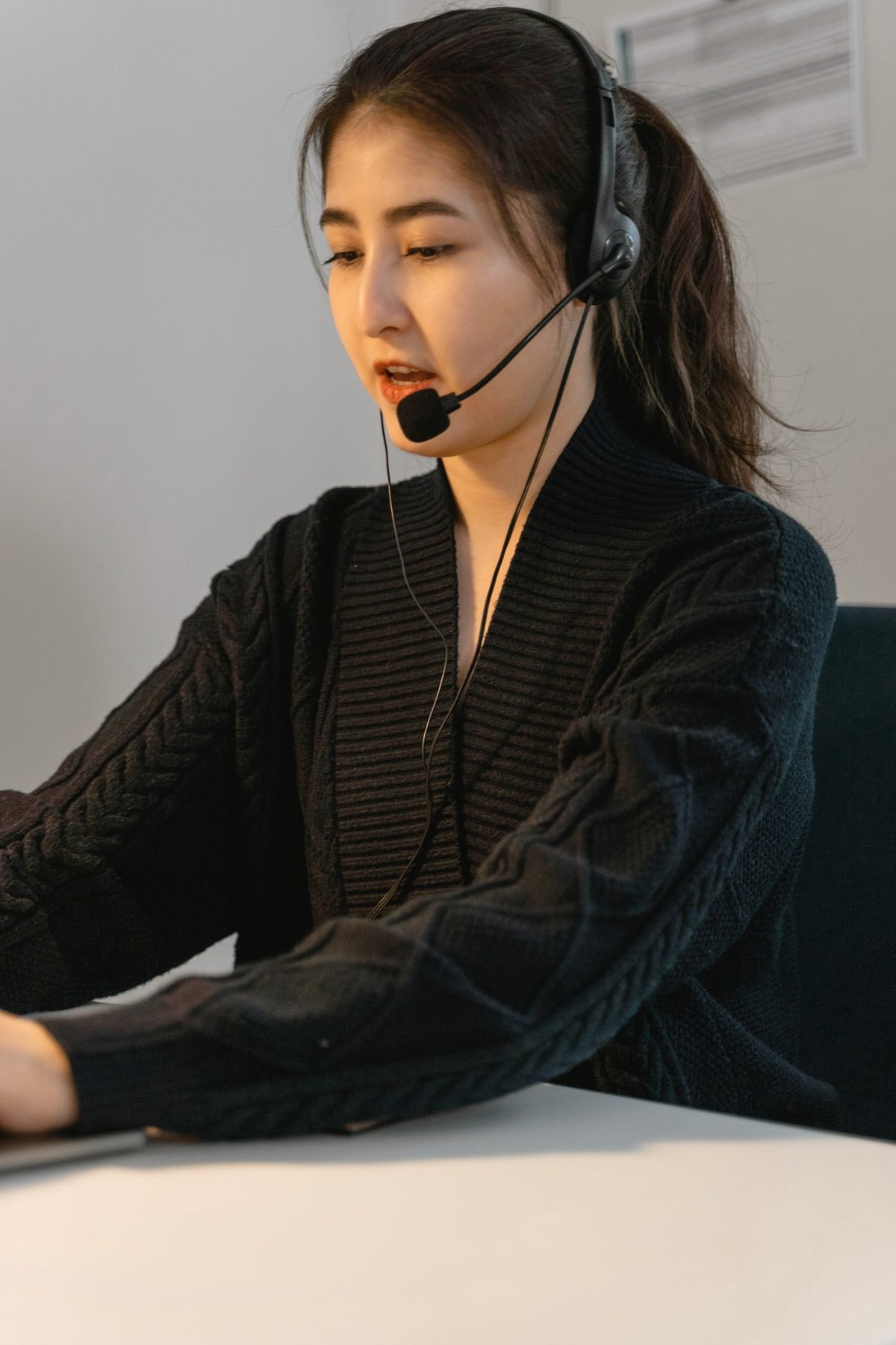 An operator in a checked blazer speaks on a headset.